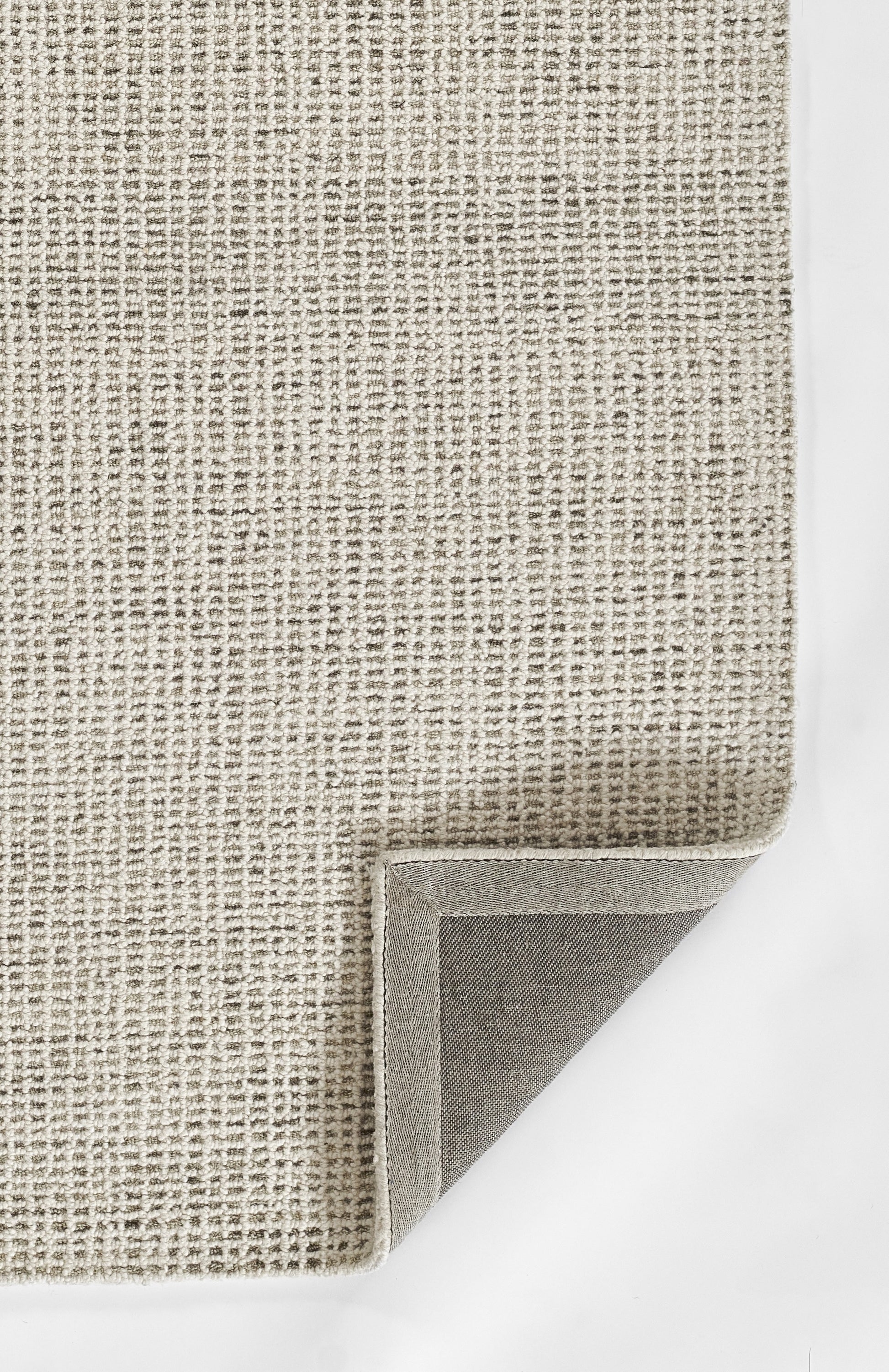 Neutral gray woven rug with textured boucle pattern, folded corner, versatile living room accent.