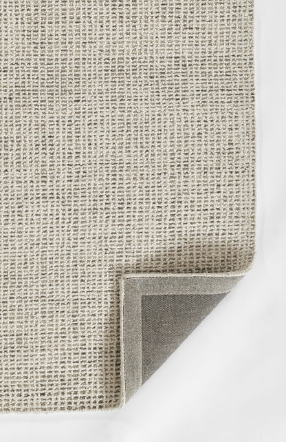 Neutral gray woven rug with textured boucle pattern, folded corner, versatile living room accent.