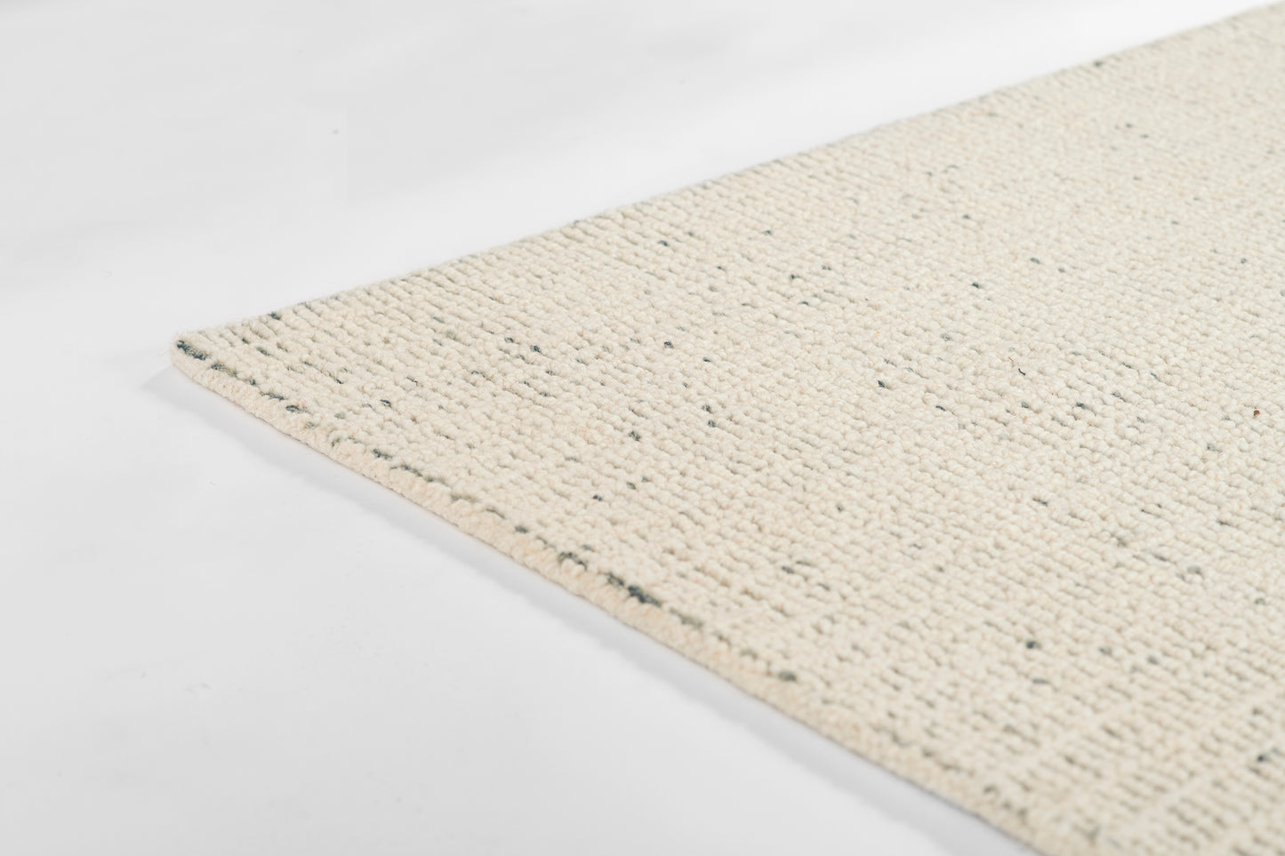 Cream woven jute rug with looped texture and speckled fibers, natural rectangular floor mat.