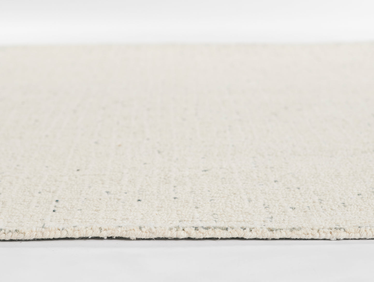 Beige flat-weave rug with natural fibers and subtle speckle, rectangular neutral living-room floor covering.