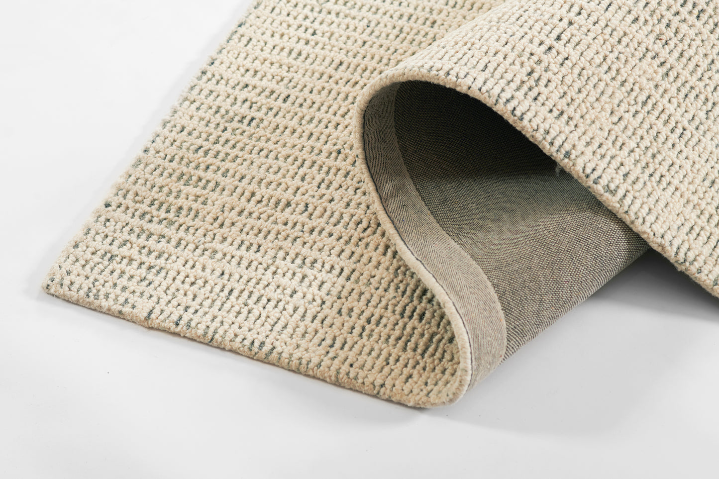 Gray textured woven rug with a subtle grid pattern, rolled edge exposing gray backing; modern, durable home decor.