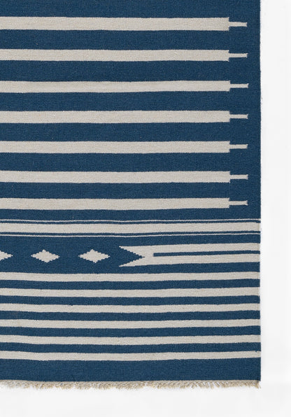 Navy blue rug with white horizontal stripes of varying widths and a fringed bottom edge.