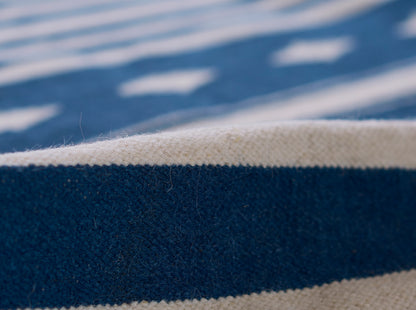 Close-up of blue and cream striped woven rug runner with textured fibers.
