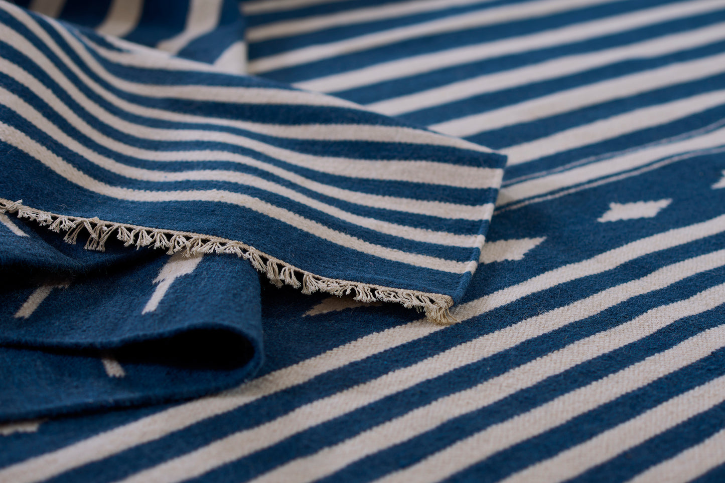 Blue and white striped woven rug with fringed edge, coastal style, 2' x 3'.