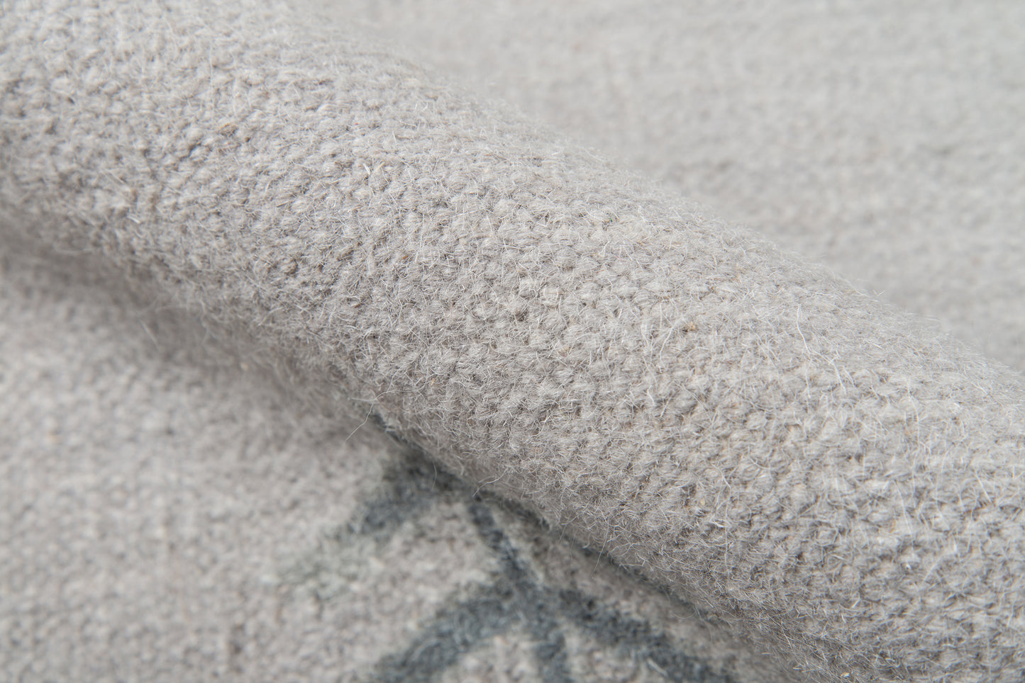 Close-up of a soft gray boucle knit rug runner with fuzzy fibers, cozy and warm texture.