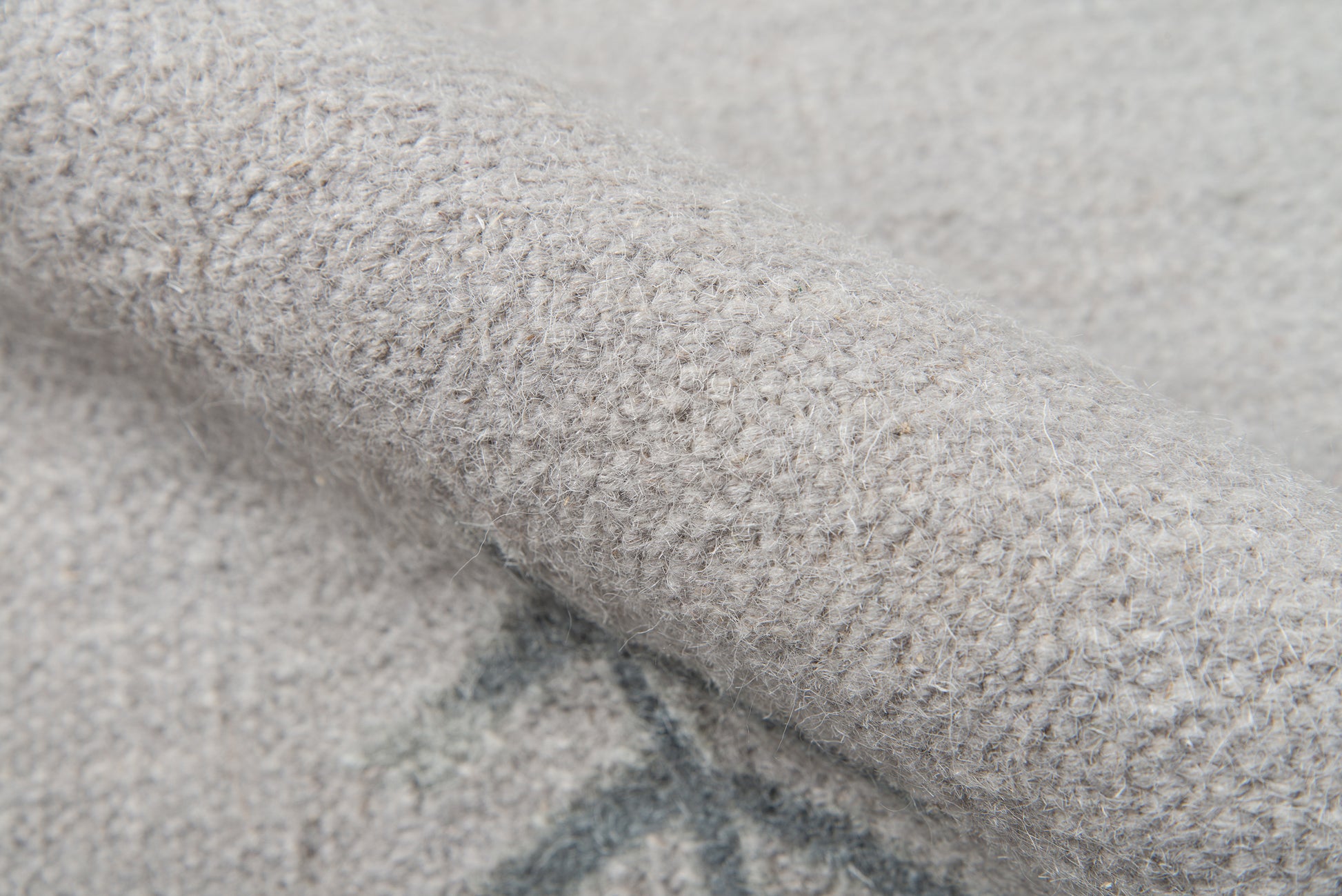 Close-up of a soft gray boucle knit rug runner with fuzzy fibers, cozy and warm texture.