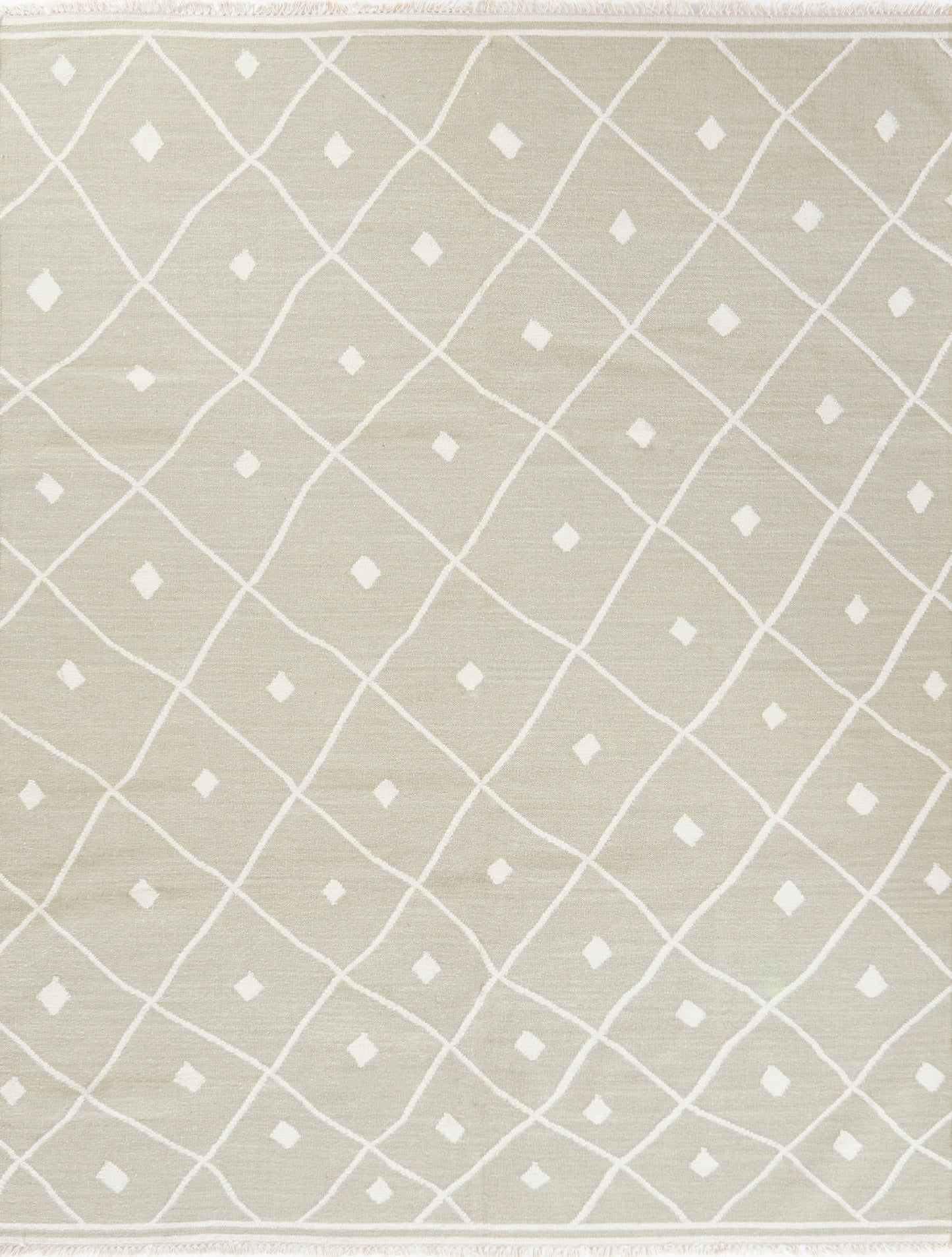 Beige woven rug with white diamond lattice pattern, small diamonds at intersections, with fringed edges.