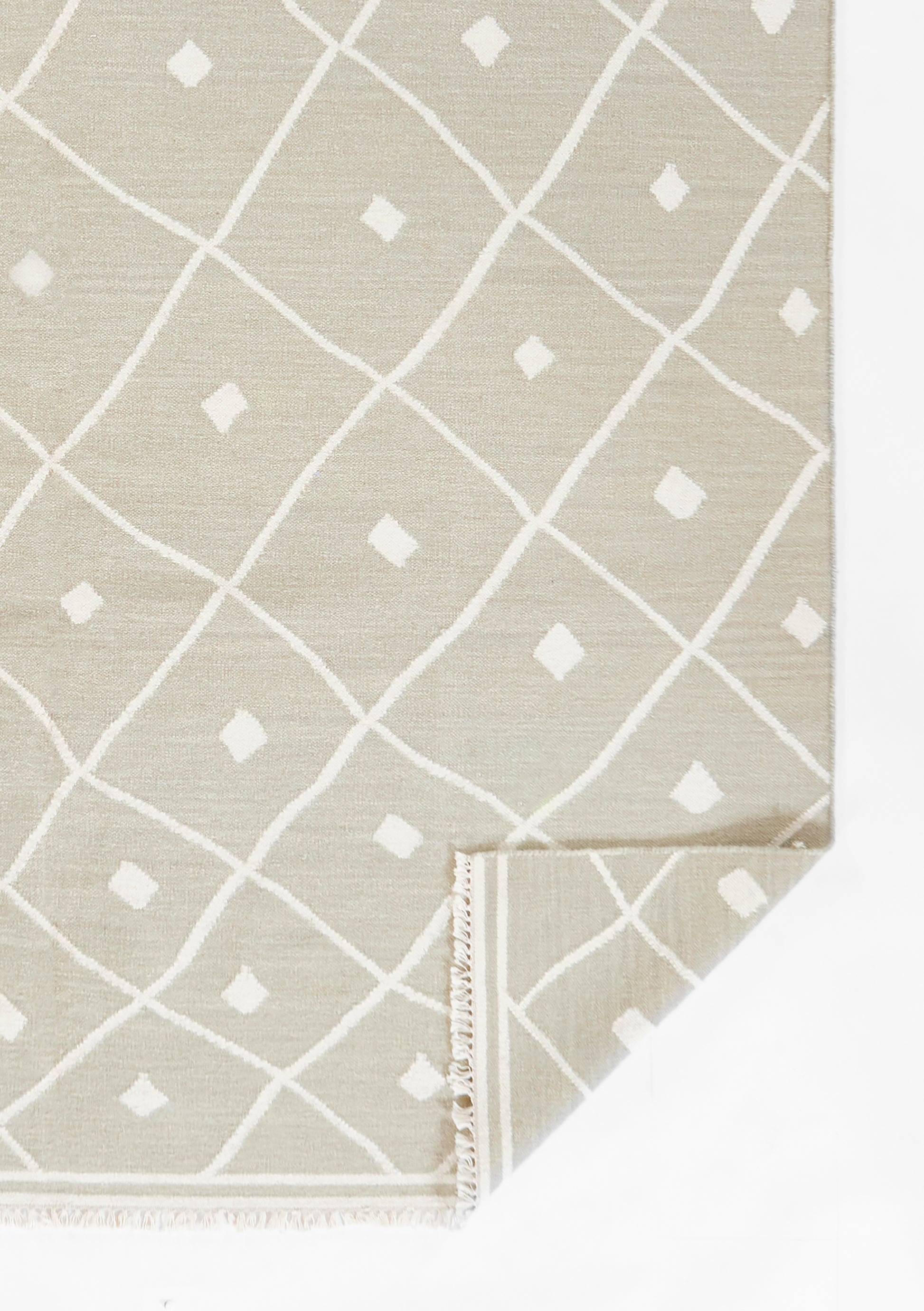 Beige woven rug with white diamond lattice pattern and small diamond accents; fringed edges, rectangular for living room.