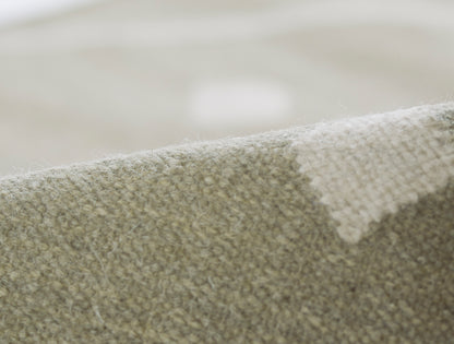 Beige and olive woven rug close-up with boucle texture and soft pile.