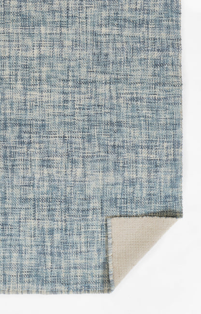 Blue and ivory geometric woven rug with distressed texture; beige backing peeks from corner.