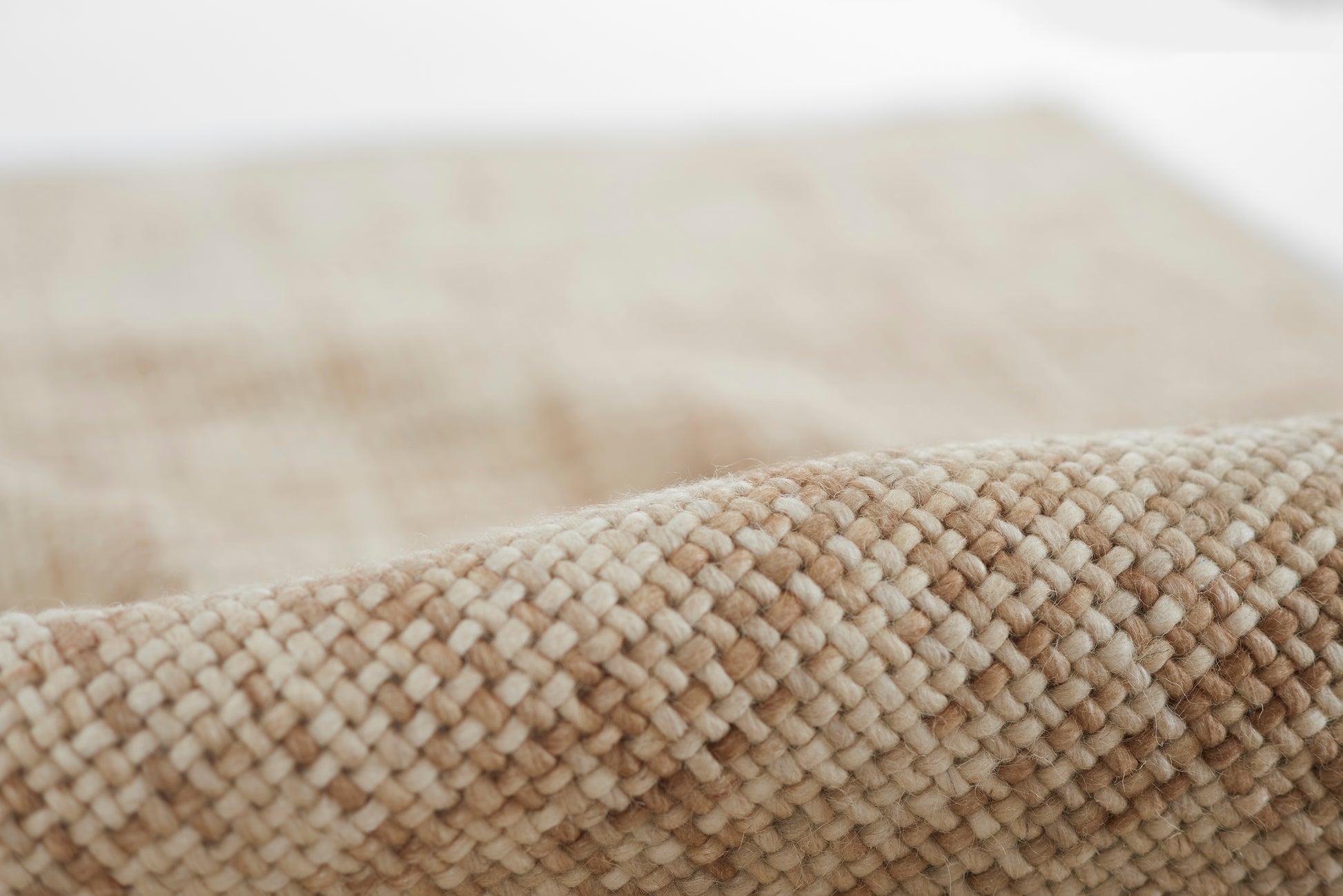 Close-up of natural beige woven rug with thick looped fibers for floor decor.