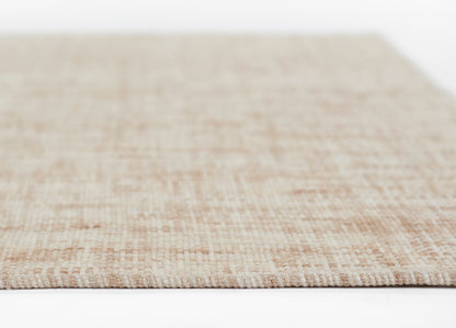 Beige flat-weave rug with natural fiber texture, close-up edge in soft pink-beige tones.