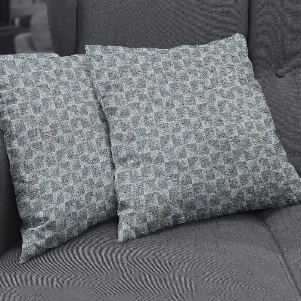Slate geometric fabric NJ25-3290; blue-gray square throw pillows with a diamond pattern on a gray sofa.