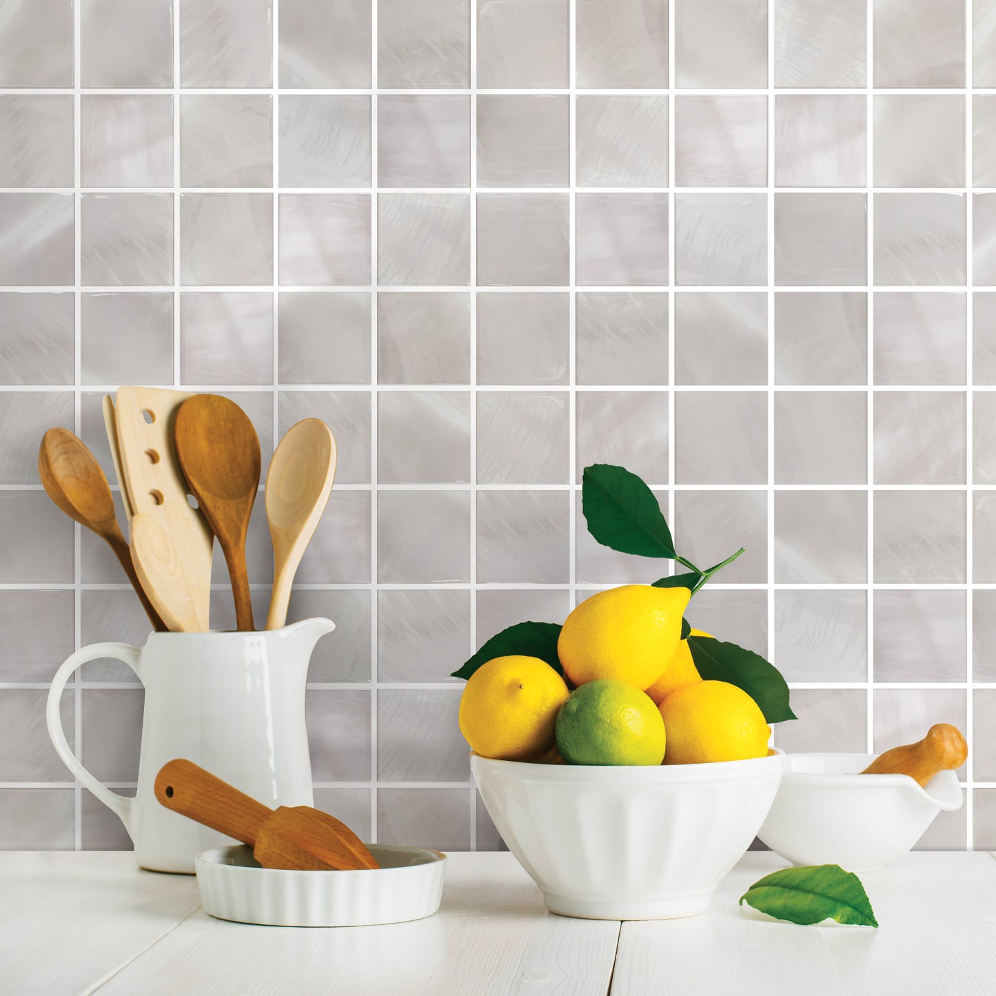 White square peel-and-stick wallpaper tiles arranged in a grid on a wall; whites and off-whites.