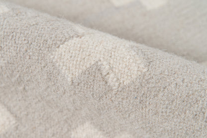 Close-up of a soft light gray rug with a fuzzy texture and visible fibers.