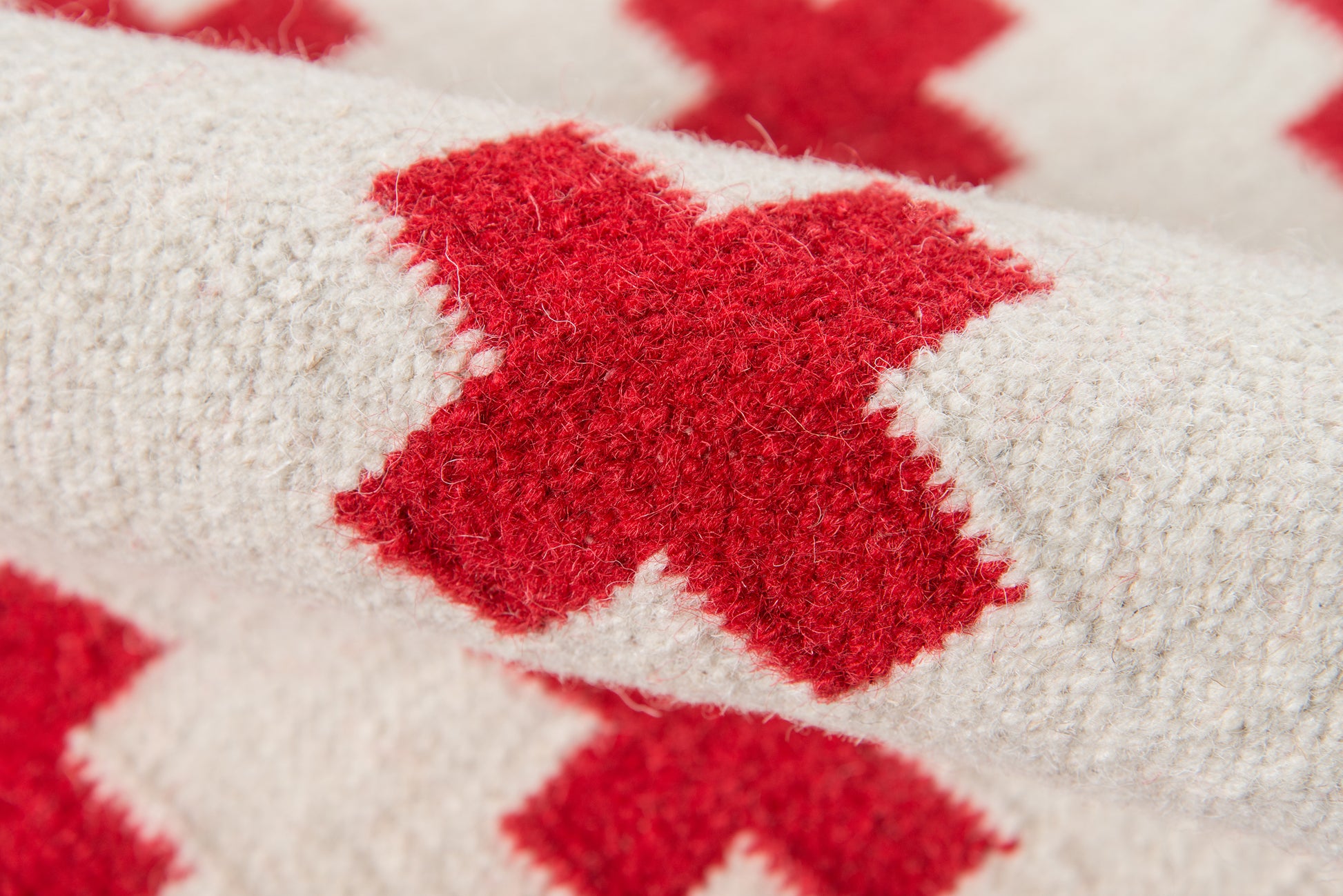 Close-up of textured cream boucle rug with red diamond pattern; 5' x 8' rug.