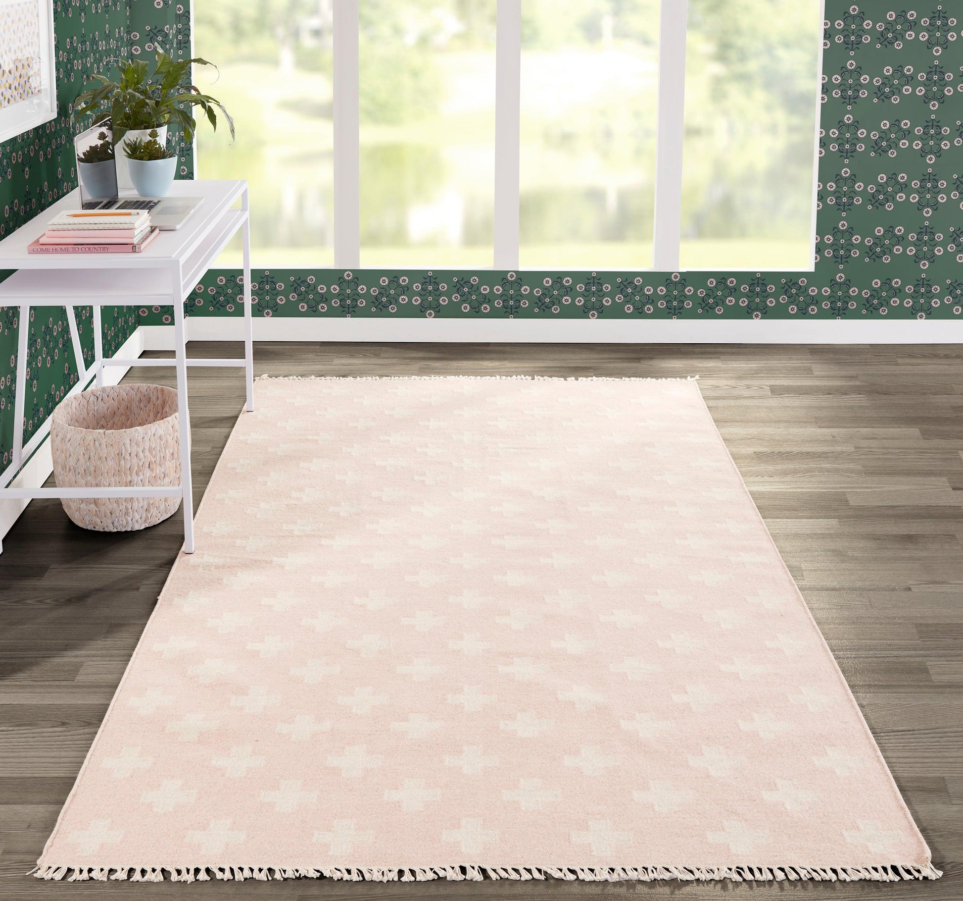 Soft pink rectangular rug with fringe tassels, ideal for cozy living room decor.