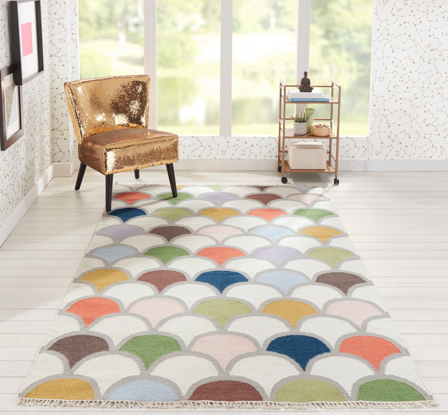 Multicolor scallop-pattern area rug in a bright living room with a gold sequin chair and a wooden rolling cart.