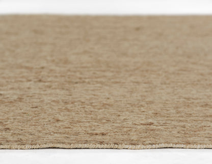 Natural beige jute runner close-up with fringe edge, rustic rectangular floor rug for living room or entryway.