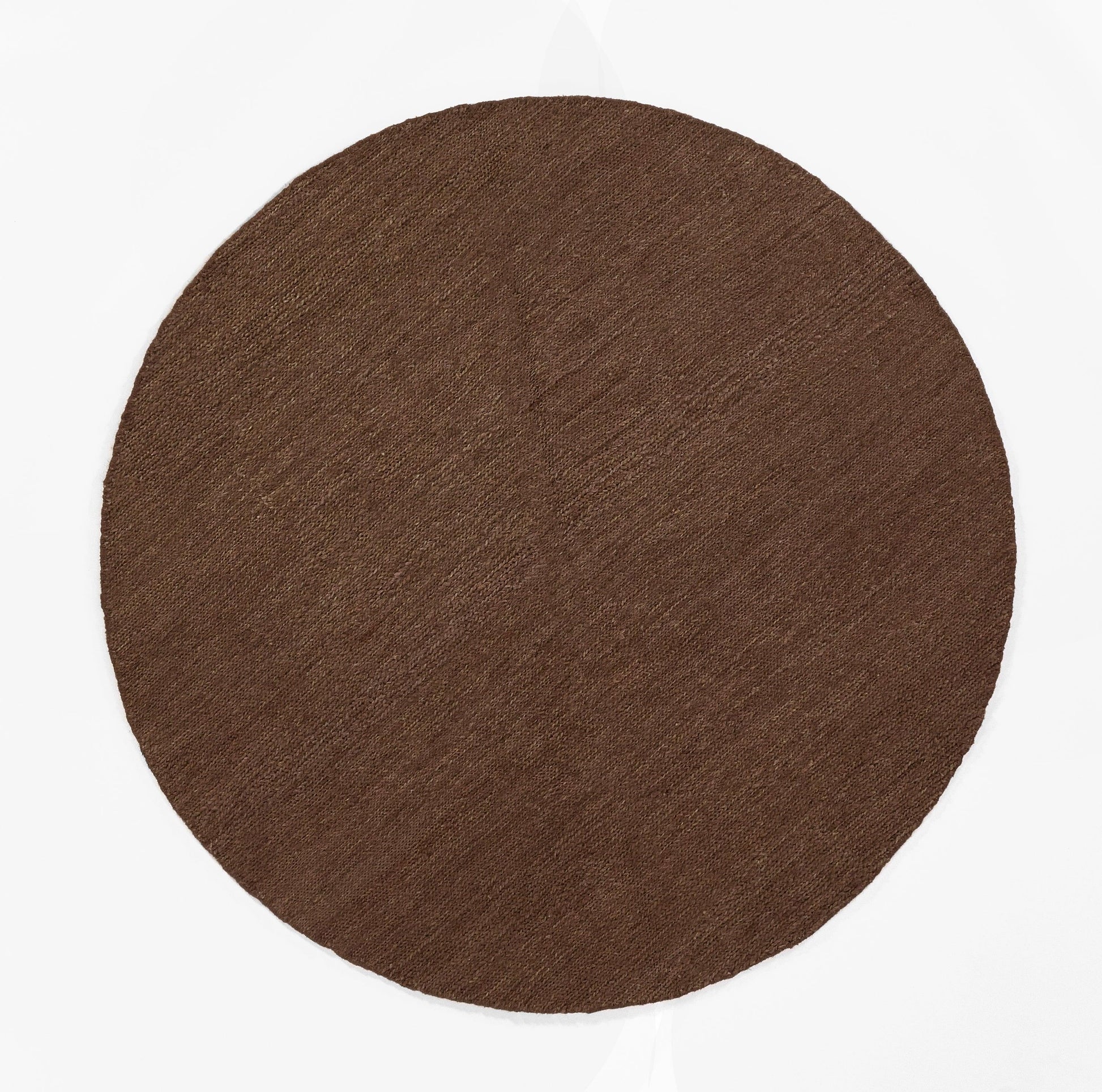 Round brown pressed pigment disc with matte finish; cocoa shade.