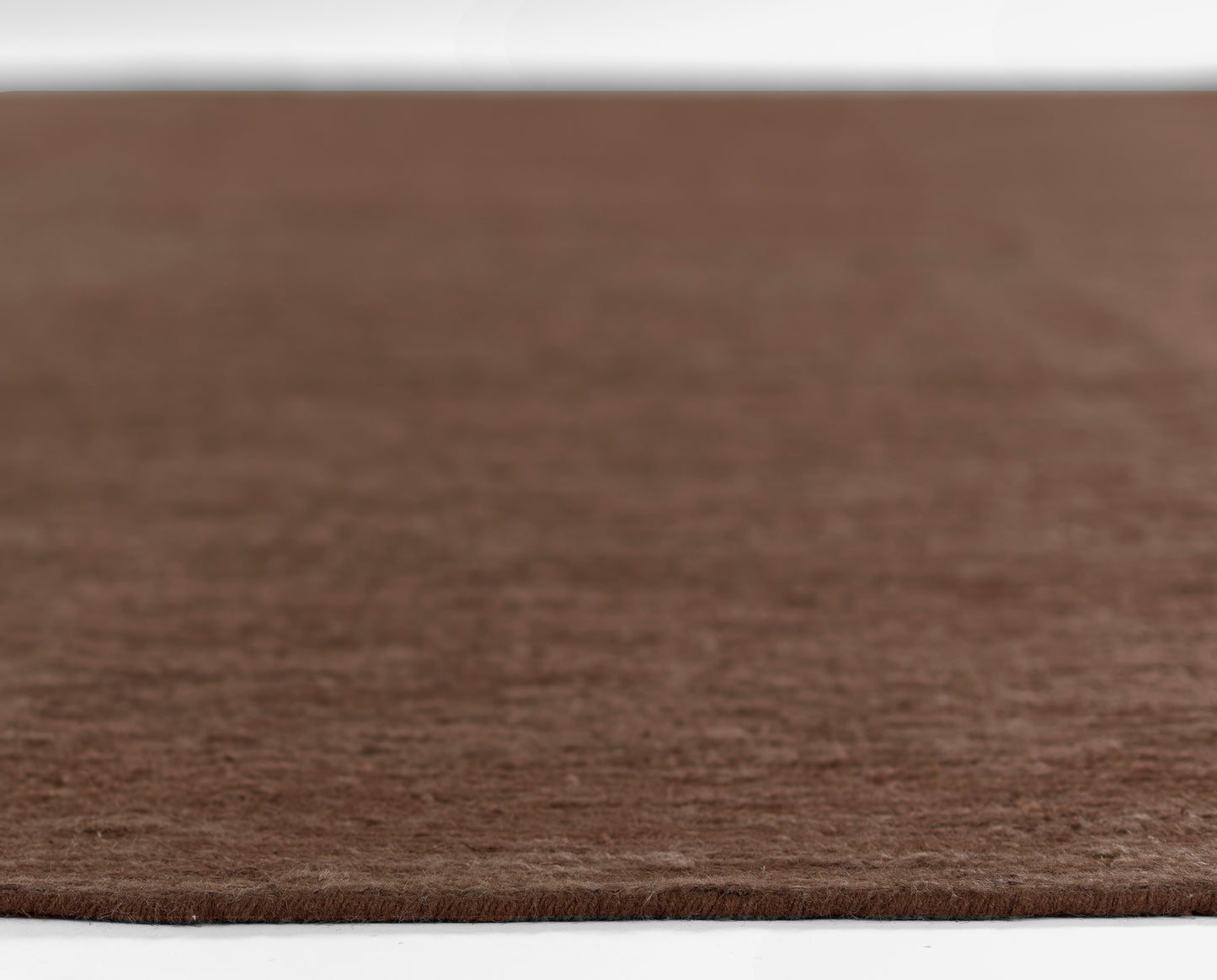 Brown circular shag rug with soft wool-like texture; round floor mat for living areas.
