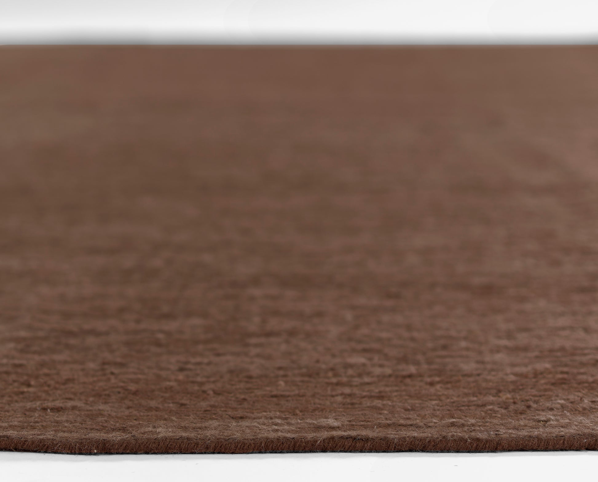 Brown circular shag rug with soft wool-like texture; round floor mat for living areas.
