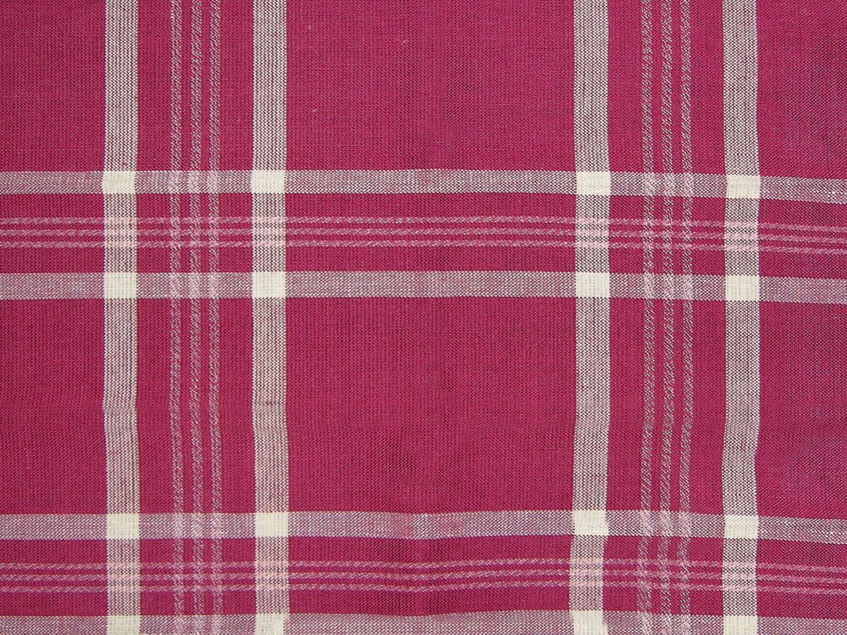 Magenta plaid woven fabric with white cross stripes in a classic tartan pattern.