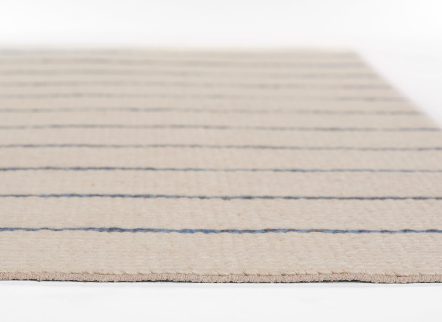 Beige woven area rug with navy horizontal stripes, flat-weave texture and subtle fringed edges