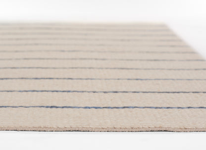 Beige woven area rug with navy horizontal stripes, flat-weave texture and subtle fringed edges