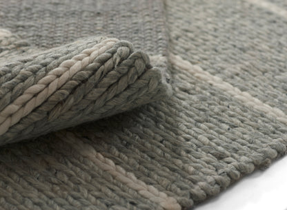 Chunky gray rug with cream stripe, braided rope texture and rolled edge—cozy floor mat.
