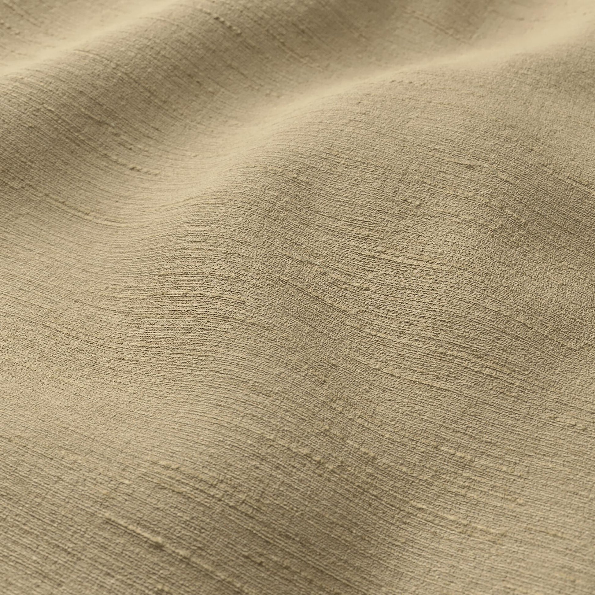 Beige-tan crepe fabric close-up with soft drape and strie texture.