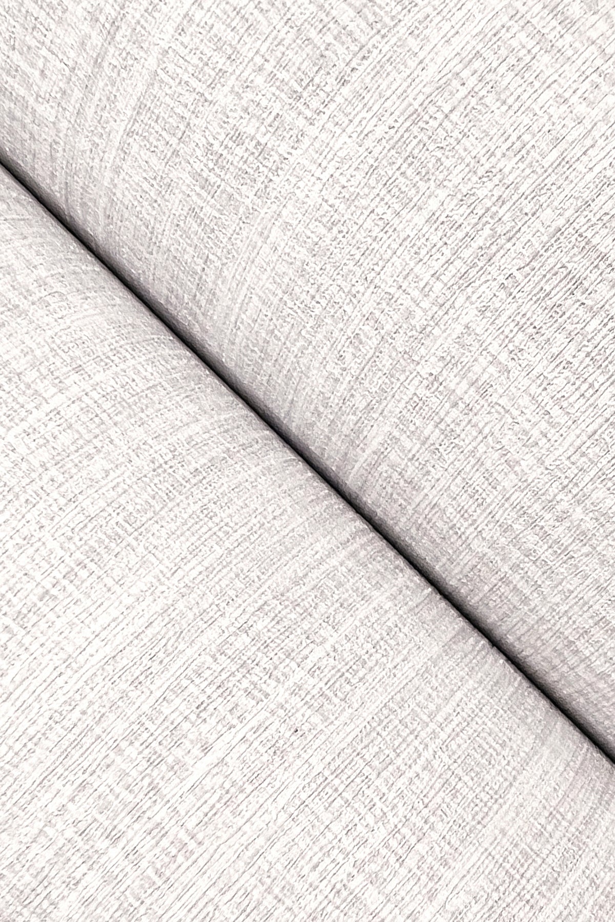 Close-up of light gray, textured wallpaper with a subtle pattern.