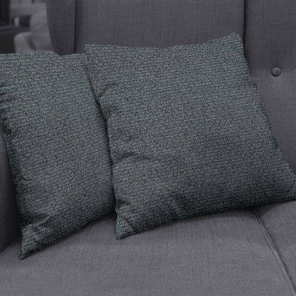 Two square dark teal textured boucle throw pillows on a charcoal sofa.