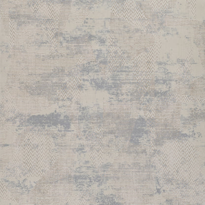 Abstract geometric area rug in beige and blue-gray tones with chevron and triangle patterns.