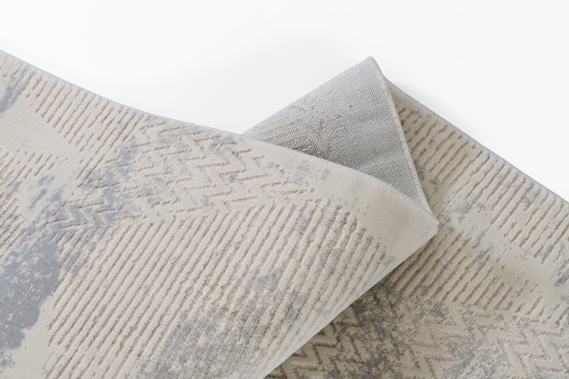 Muted beige and gray runner rug with chevron stripes and abstract shapes, soft woven pile.