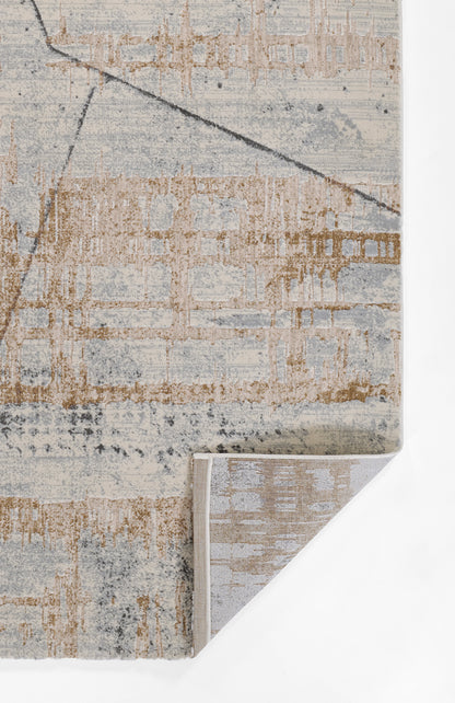 Abstract blue and tan area rug with a distressed geometric pattern; woven texture and a folded corner showing grey backing.