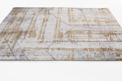 Modern rectangular area rug in pale blue with tan distressed geometric lines.