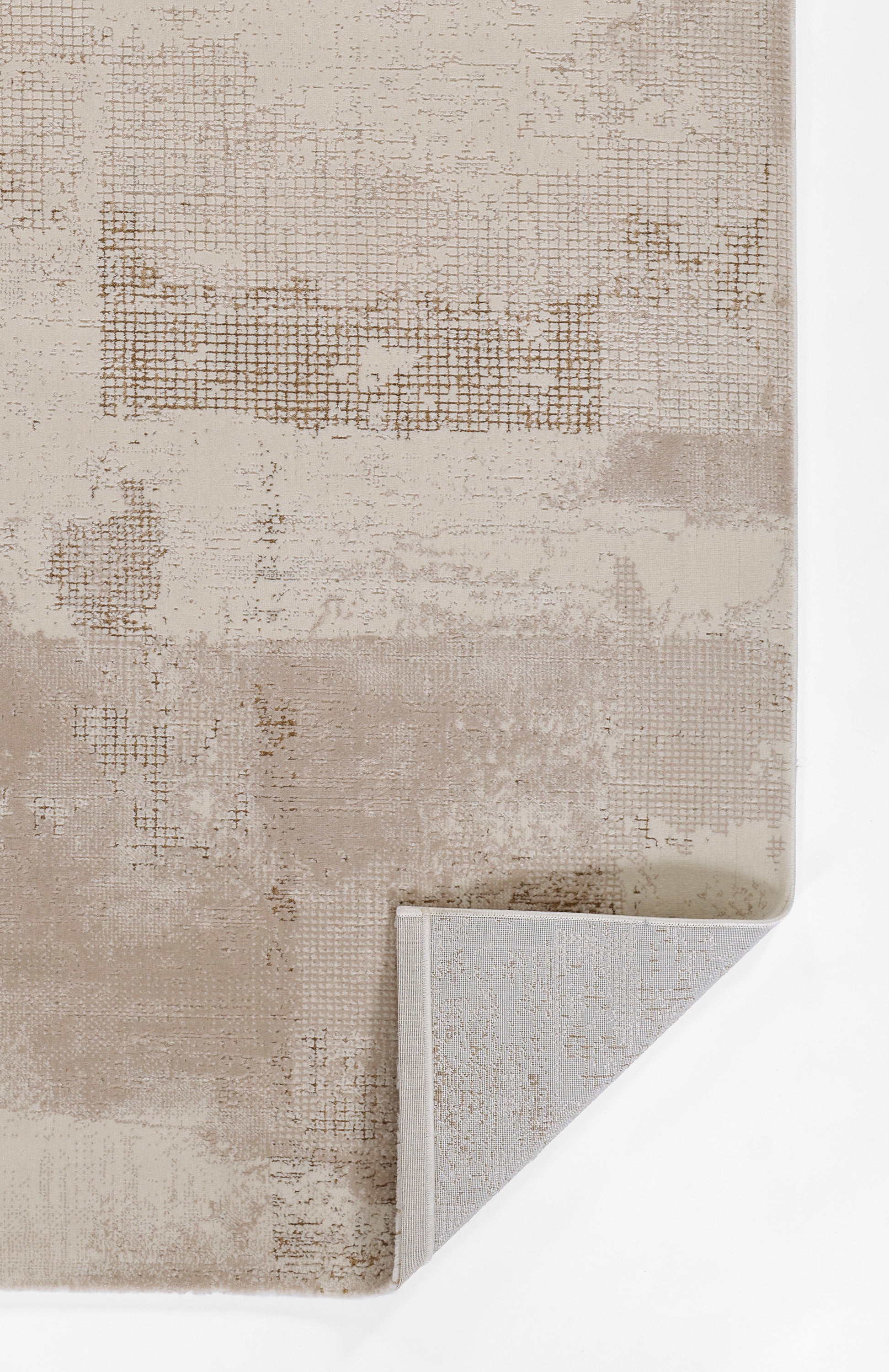 Beige abstract area rug with patchwork grid textures in taupe tones; folded corner reveals a light gray backing.