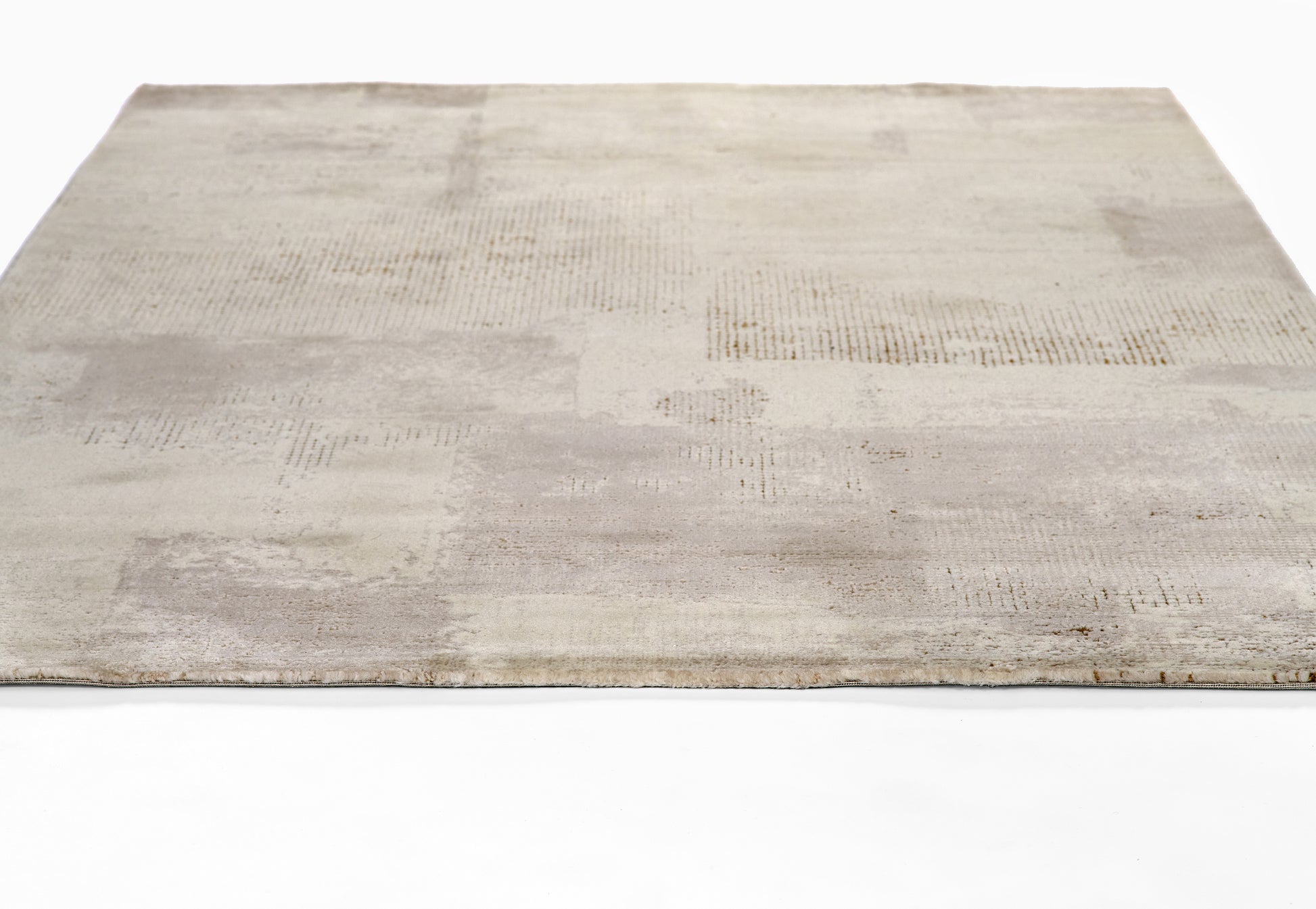 Rectangular rug in ivory and pale gray patchwork, abstract square blocks, low-pile, modern decor.