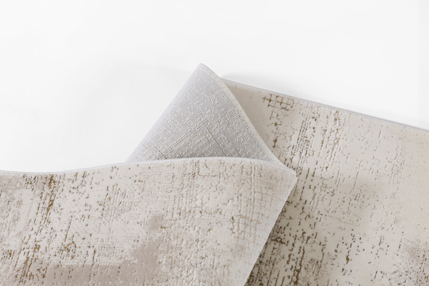 Ivory-beige area rug with subtle distressed brown-taupe pattern, soft plush texture, folded corner reveals gray backing.