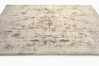 Beige distressed area rug with muted blue-gray abstract pattern; rectangular, vintage look.