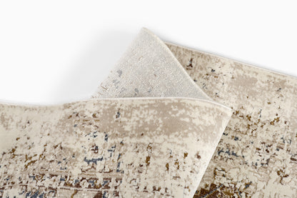 Beige distressed area rug with an abstract mottled pattern in cream, taupe & gray; rolled corner.