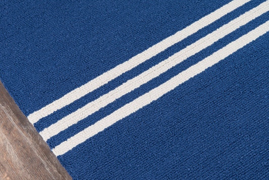 Blue rug with two parallel white stripes diagonally across, on wood floor.