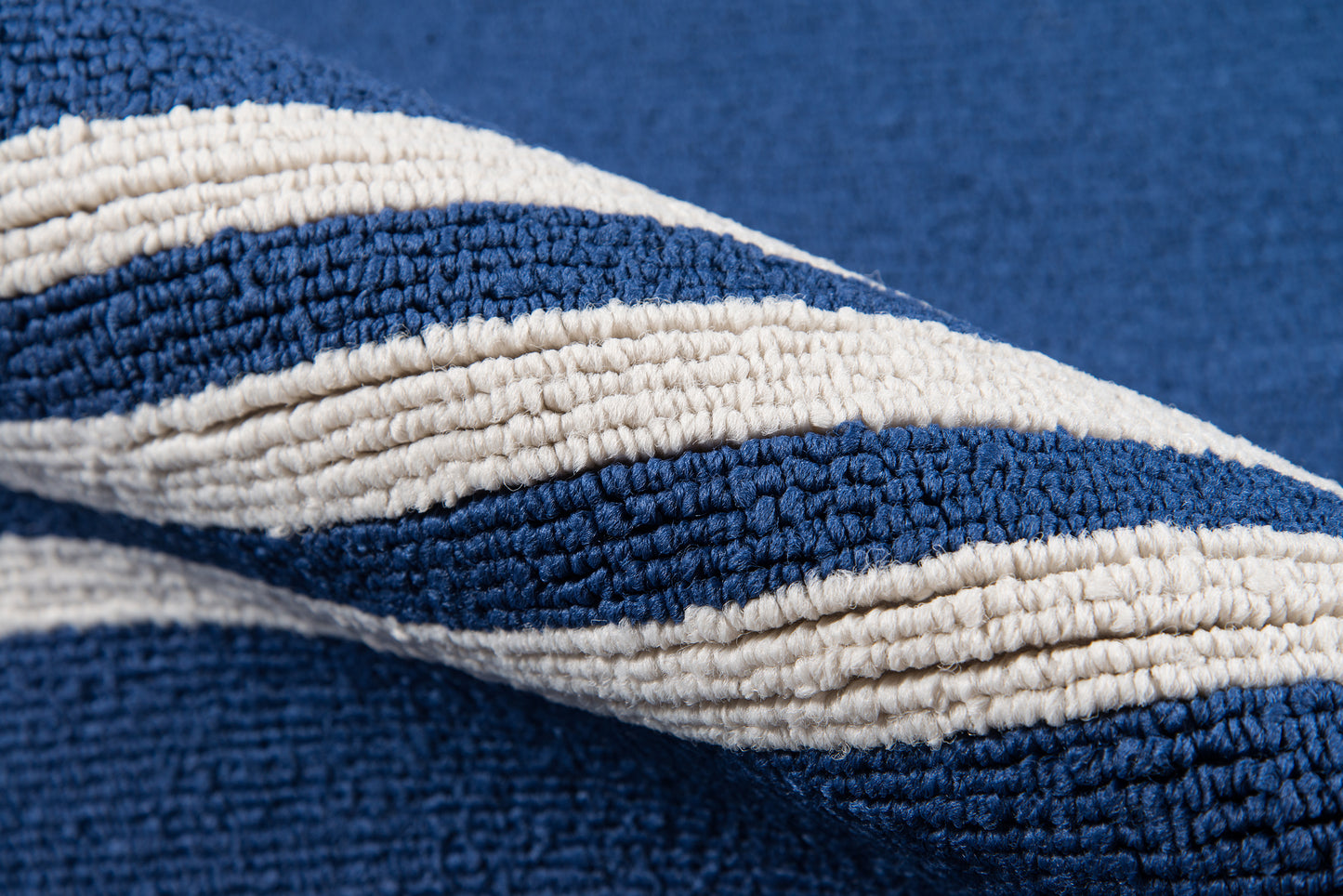 Navy blue and cream striped boucle rug with chunky woven texture for cozy home decor.