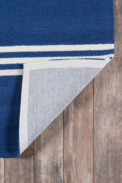Navy blue towel with white striped border, cotton terry, folded to show the soft underside on a wooden floor.