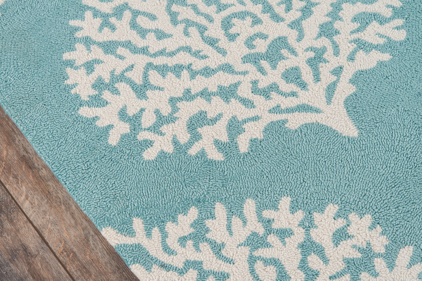 Turquoise bath mat with white coral reef pattern and soft shag texture.