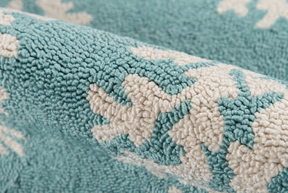 Turquoise plush rug with white abstract floral pattern; thick looped pile, cozy home decor.