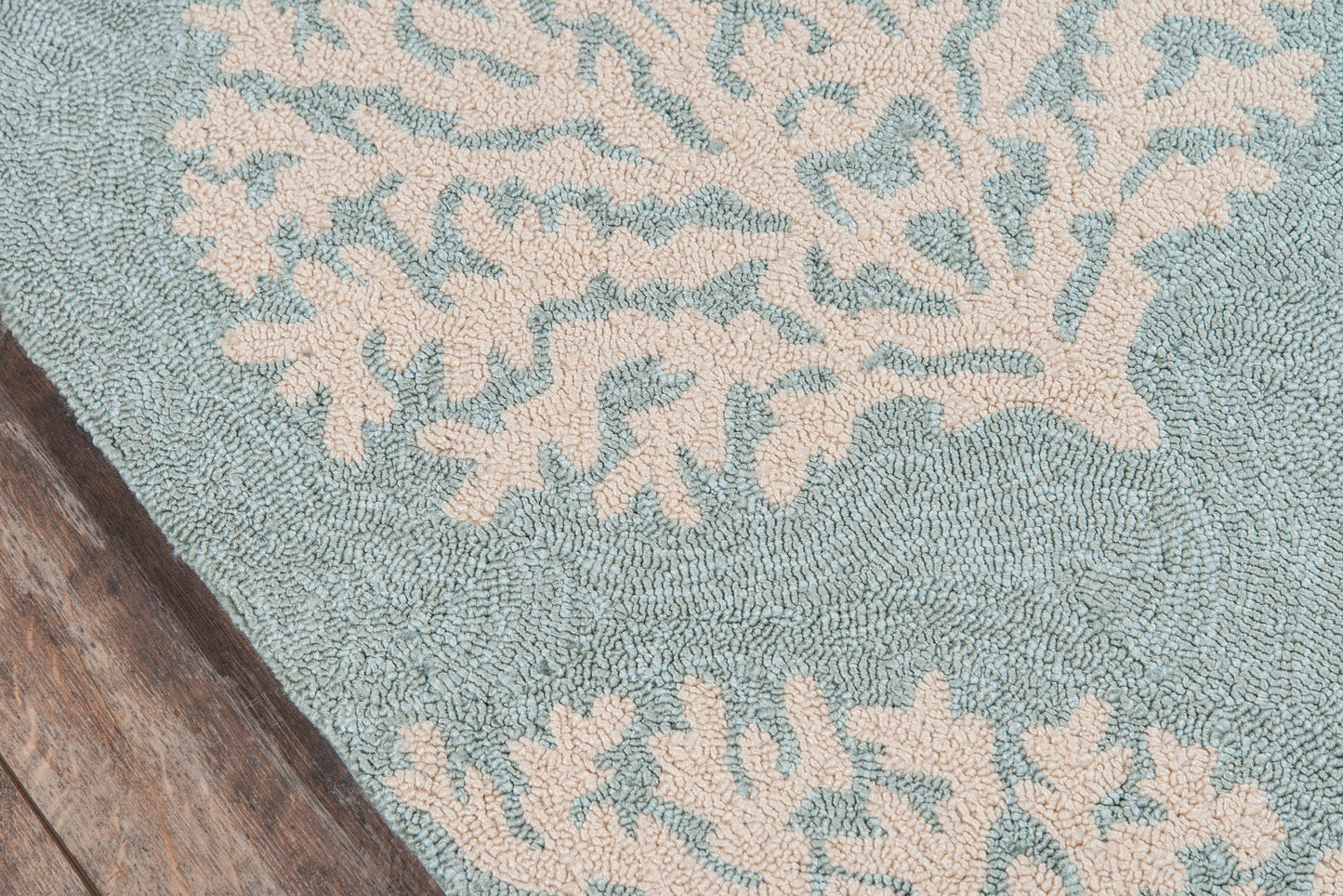 Teal rug with ivory coral motif, plush tufted texture, coastal indoor decor.