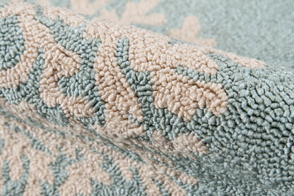 Close-up of blue and beige plush towel with damask pattern and textured looped pile.