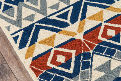 Geometric woven rug with blue, gray, mustard yellow and red diamonds and triangles on a beige background, on a wooden floor.